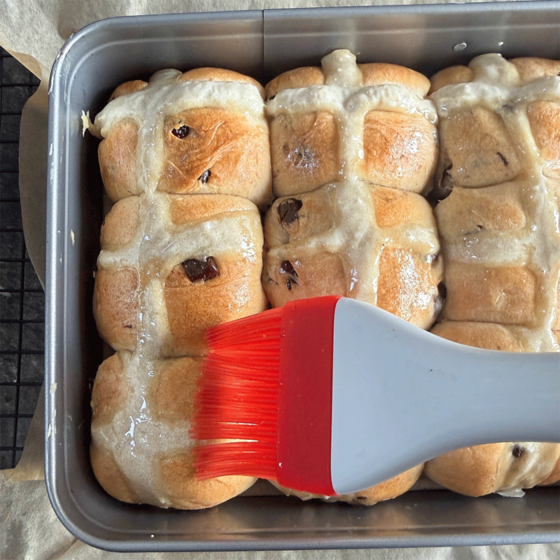 Auftragen Zuckersirup nach dem Backen der Hot Cross Buns